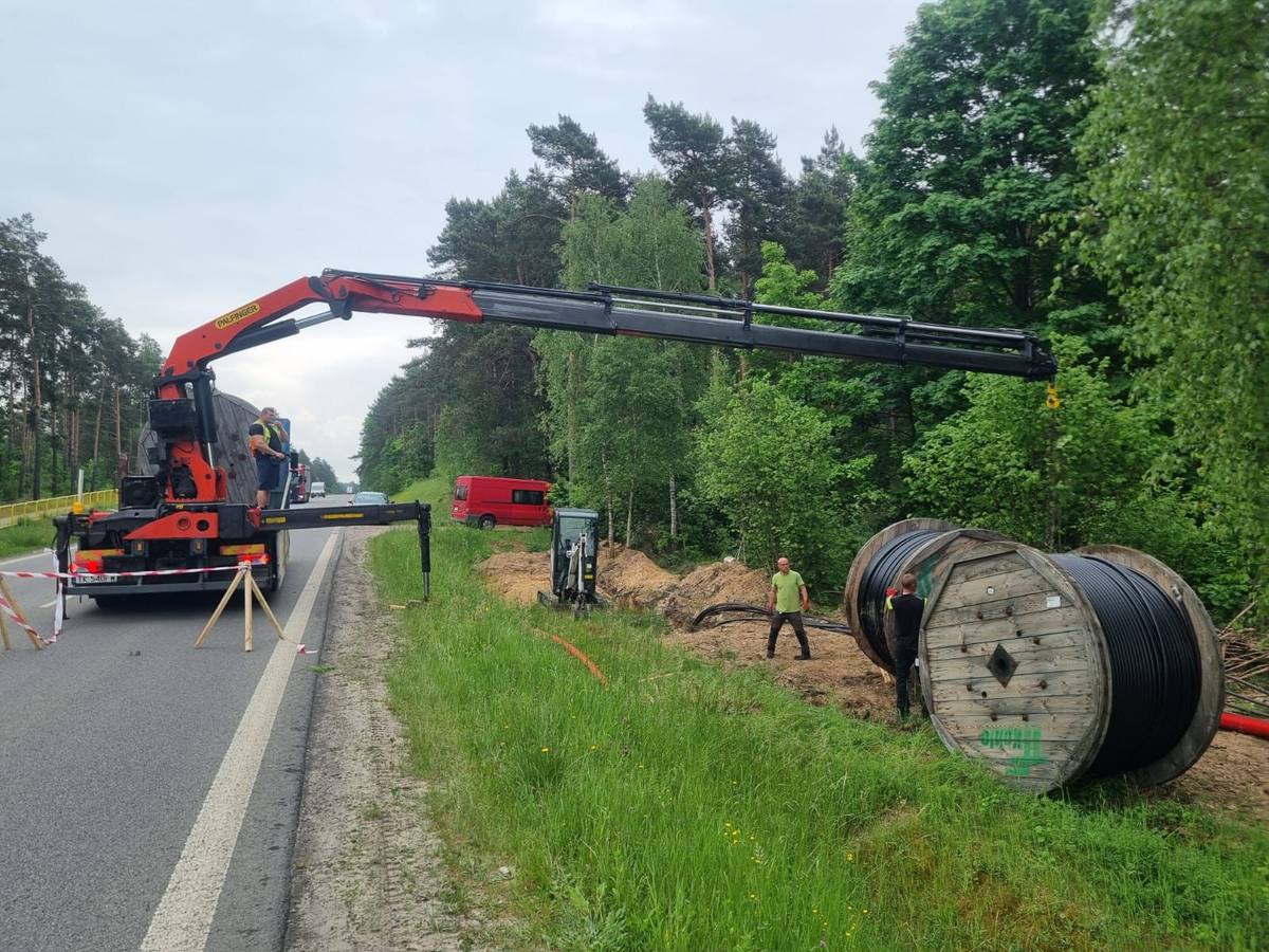 Dźwig HDS podnoszący kontener na przyczepę