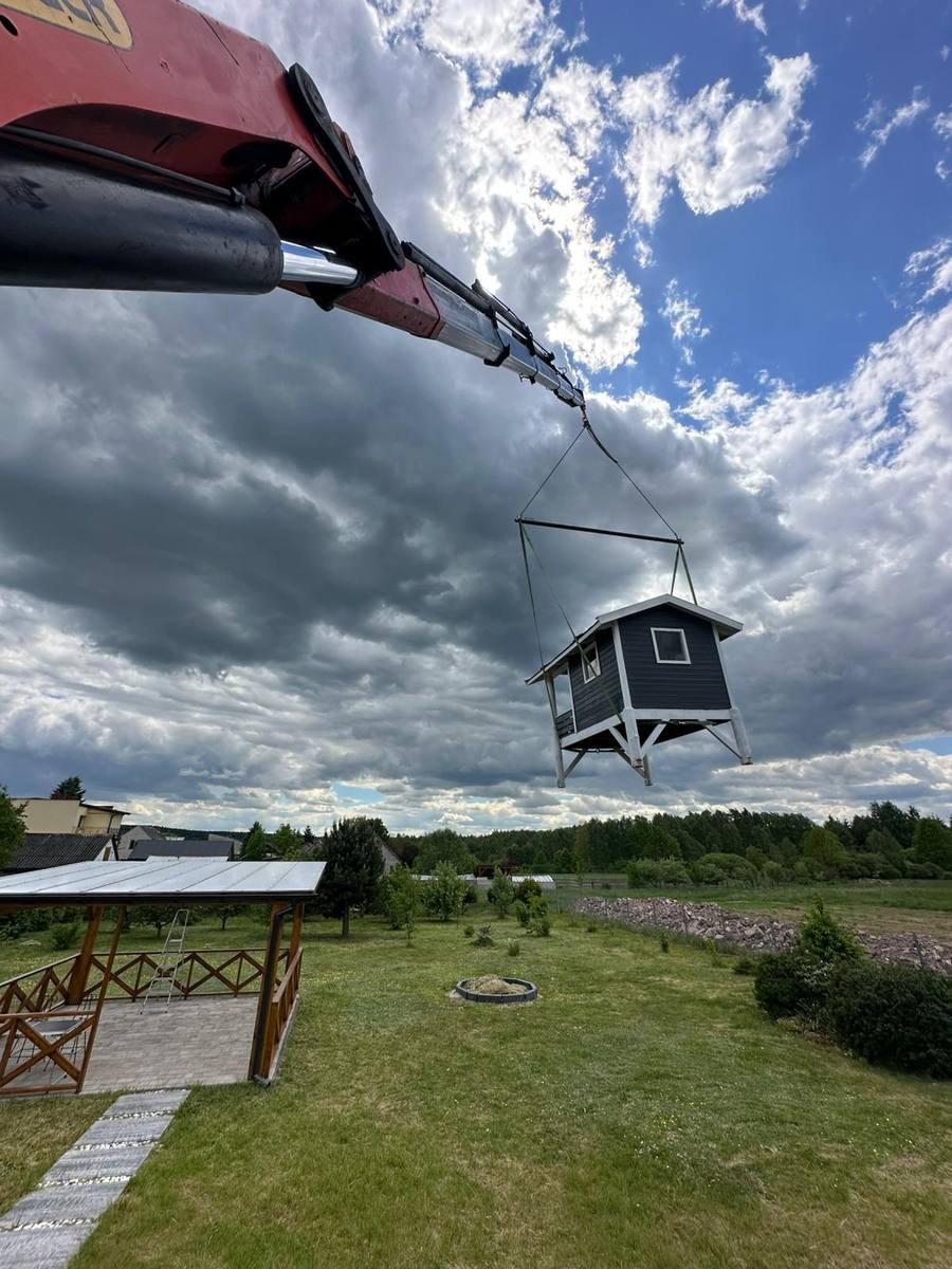 HDS przenosi domek drewniany nad ogrodem